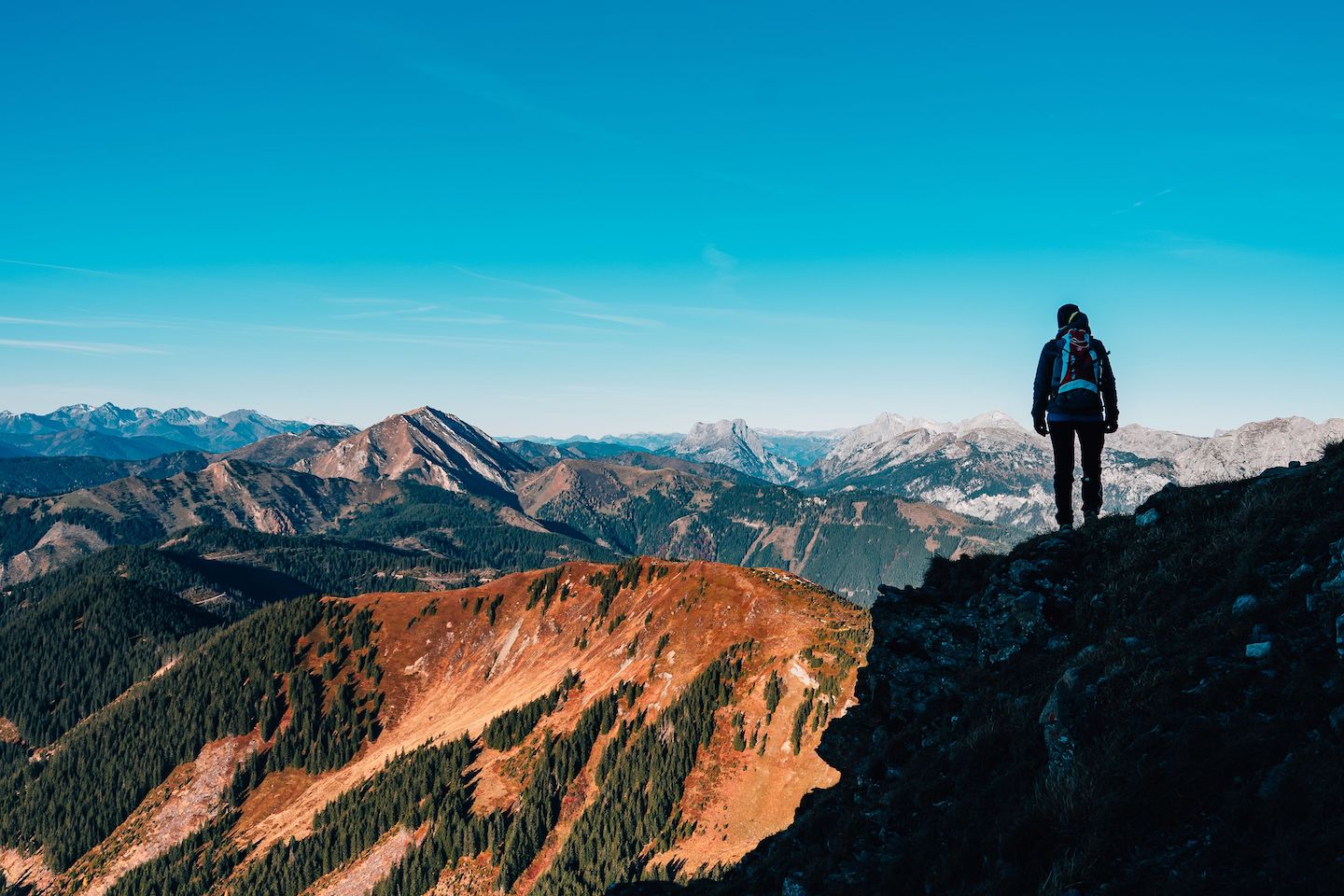 Hiker overlooking mountain range at sunrise